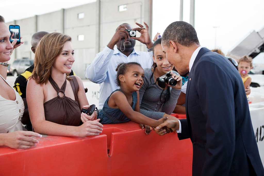: President Barack Obama shakes hands with a young girl.