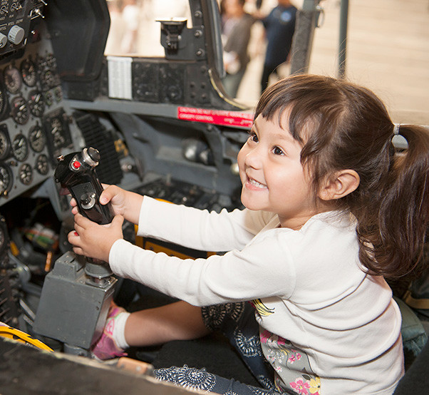 : Izadel Izzy Rosas sits in the cockpit of the F/A-18, grabs a hold of the control stick and smiles.