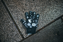 Close-up of a lost glove on the ground. Glove with halloween prints
