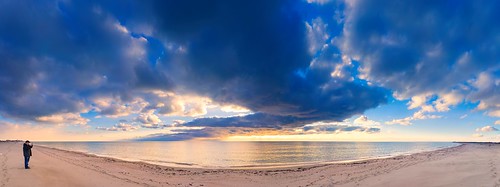 Dramatic natural landscape: cold leaden clouds reflecting in the sea, the skyline and a man standing on the sand (Panoramic landscape) ©  Alexey Fedenkov