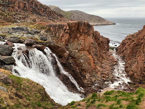 Scenic view of the waterfall flowing into the Arctic ocean against sky near Teriberka, Russia, June 2019 ©  sergei.gussev
