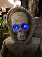 Creepy hooded skeleton with glowing blue eyes
