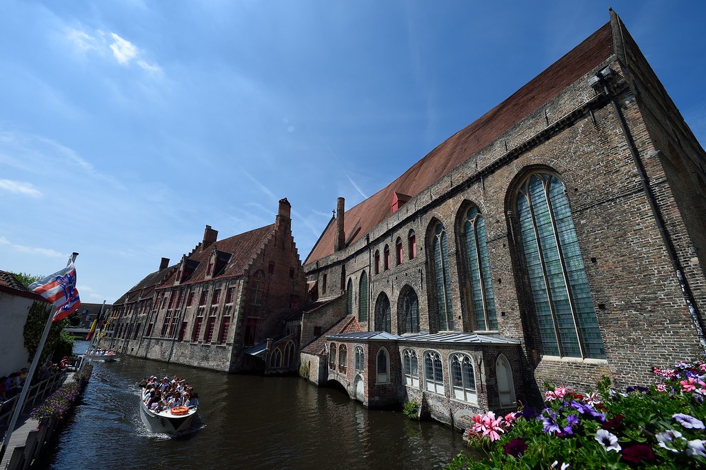 : Tour boat passes St. John's Hospital in Bruges, Belgium