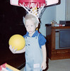 Toddler Bryan holding ball in front of basketball hoop