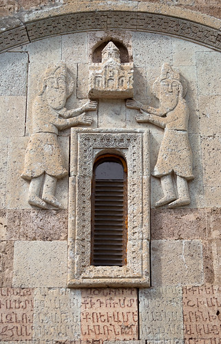 Stone carving of Armenian bearded priests raising church above window