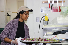 Trisha Dalapati carefully sets the vegetables on the counter after removing them from the oven at Talmage Terrace for Campus Kitchen on Feb. 12, 2019. (Photo/Paige Watkins)