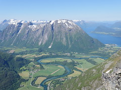 The river Rauma runs towards the sea, while the massive Romsdal Mountains stands in the back.