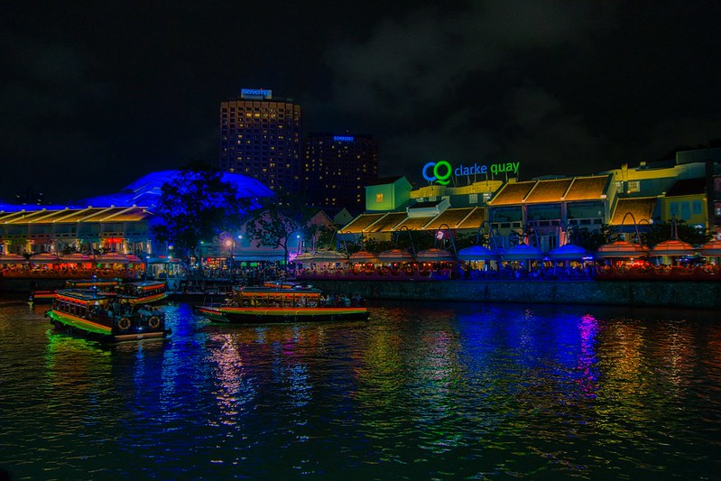 Clarke Quay with tourist bum boats at night by the Singapore river<br/>© <a href="https://flickr.com/people/8136604@N05" target="_blank" rel="nofollow">8136604@N05</a> (<a href="https://flickr.com/photo.gne?id=49681208071" target="_blank" rel="nofollow">Flickr</a>)