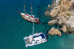 Luftbild: Katamaran und Segelboot. Die Küste von Milos (Griechenland) auf einer Bootstour entdecken