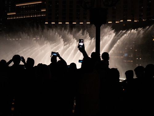 Silhouette of tourists filming the Bellagio fountains. - Las Vegas