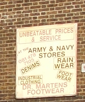 ARMY AND NAVY STORES ADVERTISING SIGN ON A WALL ON A SHOPPING STREET IN AN EAST LONDON BOROUGH SUBURB STREET  ENGLAND DSCN0096
