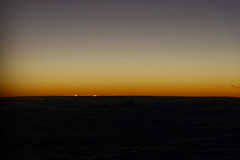 The Light from the Sun Begins to Show Itself Over a Distant Horizon Over the Clouds in the US