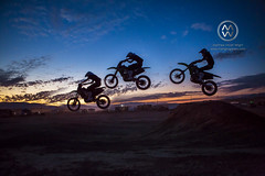 A motorcyclist jumps into the air at sunset.