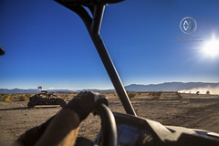 A group of off road vehicles line up to race across the desert.
