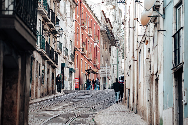 Lisbon, Portugal - January 17, 2020: Typical urban street scene, with cobblestone streets, streetcar tram tracks and overhead power lines in the narrow streets<br/>© <a href="https://flickr.com/people/39908901@N06" target="_blank" rel="nofollow">39908901@N06</a> (<a href="https://flickr.com/photo.gne?id=50646907431" target="_blank" rel="nofollow">Flickr</a>)