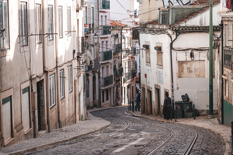 Lisbon, Portugal - January 17, 2020: Typical urban street scene, with cobblestone streets, streetcar tram tracks and overhead power lines in the narrow streets<br/>© <a href="https://flickr.com/people/39908901@N06" target="_blank" rel="nofollow">39908901@N06</a> (<a href="https://flickr.com/photo.gne?id=50670387662" target="_blank" rel="nofollow">Flickr</a>)