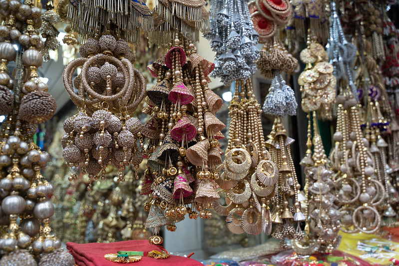 Colorful metallic decorations on display for sale in Chandi Chowk Old Delhi. These flowers, beads and bells designs are popular in weddings, festivals and events.<br/>© <a href="https://flickr.com/people/39908901@N06" target="_blank" rel="nofollow">39908901@N06</a> (<a href="https://flickr.com/photo.gne?id=50771007413" target="_blank" rel="nofollow">Flickr</a>)