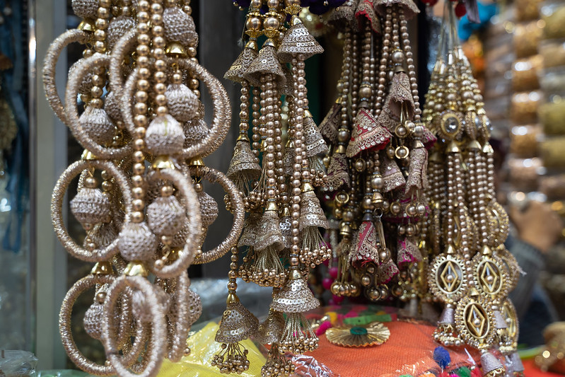 Colorful metallic decorations on display for sale in Chandi Chowk Old Delhi. These flowers, beads and bells designs are popular in weddings, festivals and events.<br/>© <a href="https://flickr.com/people/39908901@N06" target="_blank" rel="nofollow">39908901@N06</a> (<a href="https://flickr.com/photo.gne?id=50771869847" target="_blank" rel="nofollow">Flickr</a>)