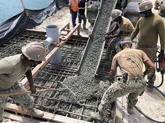 NMCB-4 places concrete for a mooring bollard at Tinian Harbor.