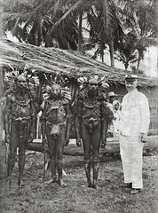 TM-60053987 Portret van een bestuursambtenaar met drie Marind Papoea mannen