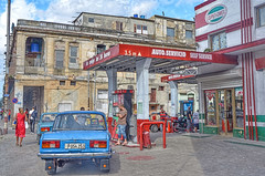 Vintage cars and bikes at Havana gas station, Cuba