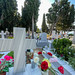 Close-up of stone cross and flowers on a tombstone at the cemetery of Greek island Skiathos