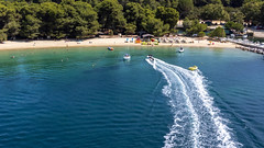 Motorboote und Aquadonuts vor dem Strand Chrysi Ammos auf Skiathos, Griechenland
