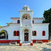 The white and red church of Agia Triada with central bell tower in Skiathos town, Greece