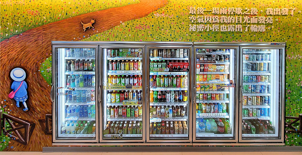 萊爾富幾米聯名主題2號店的冷藏櫃，牆上繪畫的整片綠地及小徑，搭配獨特文字，彷彿來到幾米的秘密花園中。
