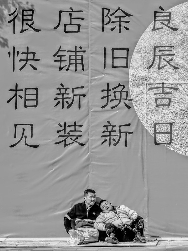 Two workers take a lunch break in front of the site curtain for a Chinese style kebab & tavern restaurant refurbishment.<br/>© <a href="https://flickr.com/people/193575245@N03" target="_blank" rel="nofollow">193575245@N03</a> (<a href="https://flickr.com/photo.gne?id=51789206836" target="_blank" rel="nofollow">Flickr</a>)