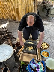 Fr. Michael Kesicki takes a turn at grinding corn to make tortillas.