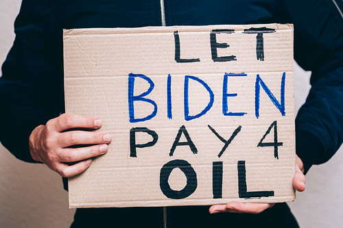 Person holding a protest sign with text .Let Biden Pay 4 Oil., From FlickrPhotos