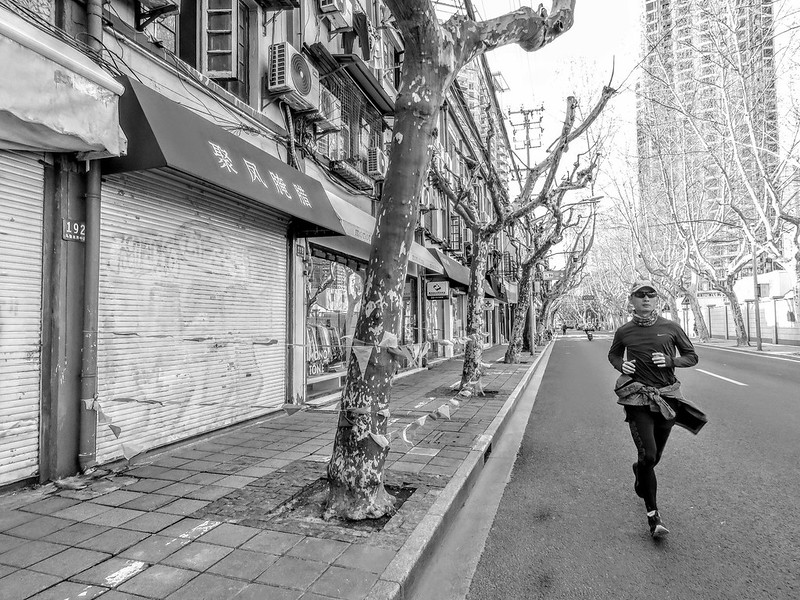 A jogger passing a roped off shop of ham and cured meat on March 23, 2022. The bankruptcy of China's epidemic prevention strategy.<br/>© <a href="https://flickr.com/people/193575245@N03" target="_blank" rel="nofollow">193575245@N03</a> (<a href="https://flickr.com/photo.gne?id=52049433101" target="_blank" rel="nofollow">Flickr</a>)
