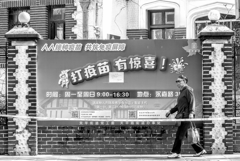 An elderly woman walking past a government advertisement for ineffective vaccinations on 15 March, when vaccinations had been halted due to fears of crowds gathering as the epidemic spread. China's epidemic prevention is a disastrous joke.<br/>© <a href="https://flickr.com/people/193575245@N03" target="_blank" rel="nofollow">193575245@N03</a> (<a href="https://flickr.com/photo.gne?id=52065794846" target="_blank" rel="nofollow">Flickr</a>)