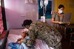 Cmdr. Myra Cleary provides a pediatric checkup on a child at Belau National Hospital during Pacific Partnership 2022.