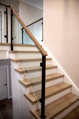 Modern stair, with glass panels + metal posts + wood handrail