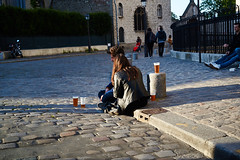Young people sitting and enjoying the sun in front of the Basilica of the Sacred Heart, Montmartre, Paris, France