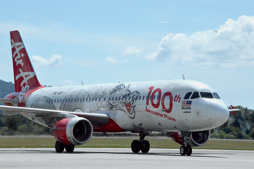 An AirAsia Airbus A320 in the 100th Awesome Plane livery taxiing towards the gate at Langkawi International Airport