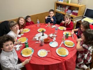 Sunday School kids enjoying spaghetti at the annual Christmas luncheon