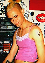 blond Me with combed mohawk in pink top at home in front of my old stereo and walled cluttered wall (vintage me from the past)