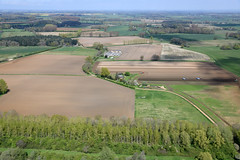 Aerial image: Roxham Farm - site of a Norfolk lost village. Deserted by the 16th century. Cropmarks of the village can be seen in the field, south west of the farm.