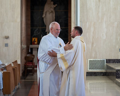 Newly ordained Deacon Luke Daghir is greeted by Deacon Denis Coan.