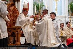 Newly ordained Fr. Cory Pius receives the chalice and paten from Bishop Persico.