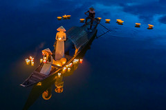 Women in traditional Ao Dai light lanterns on the Perfume river, Hue, Vietnam.