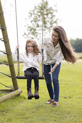 Mother and Daughter Playing on Swings