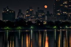 The Waxing Gibbous moon rises over the East Side of Manhattan and is reflected in the Jacqueline Kennedy Onassis Reservoir in Central Park.