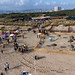 Aerial view of people on vacation at a popular sandy beach with sun umbrellas in Lisbon, Portugal