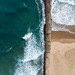 Aerial Picture of wavy Atlantic Ocean and sand beach, divided by wave breaker