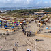 Luftaufnahme zeigt Urlauber am beliebten Sandstrand mit Sonnenschirmen in Lissabon, Portugal