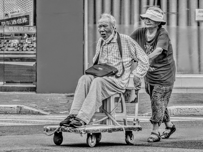 The old man going home from the hospital, crossing the street by sitting in his "wheelchair" pushed by his elderly wife.<br/>© <a href="https://flickr.com/people/193575245@N03" target="_blank" rel="nofollow">193575245@N03</a> (<a href="https://flickr.com/photo.gne?id=53138463228" target="_blank" rel="nofollow">Flickr</a>)
